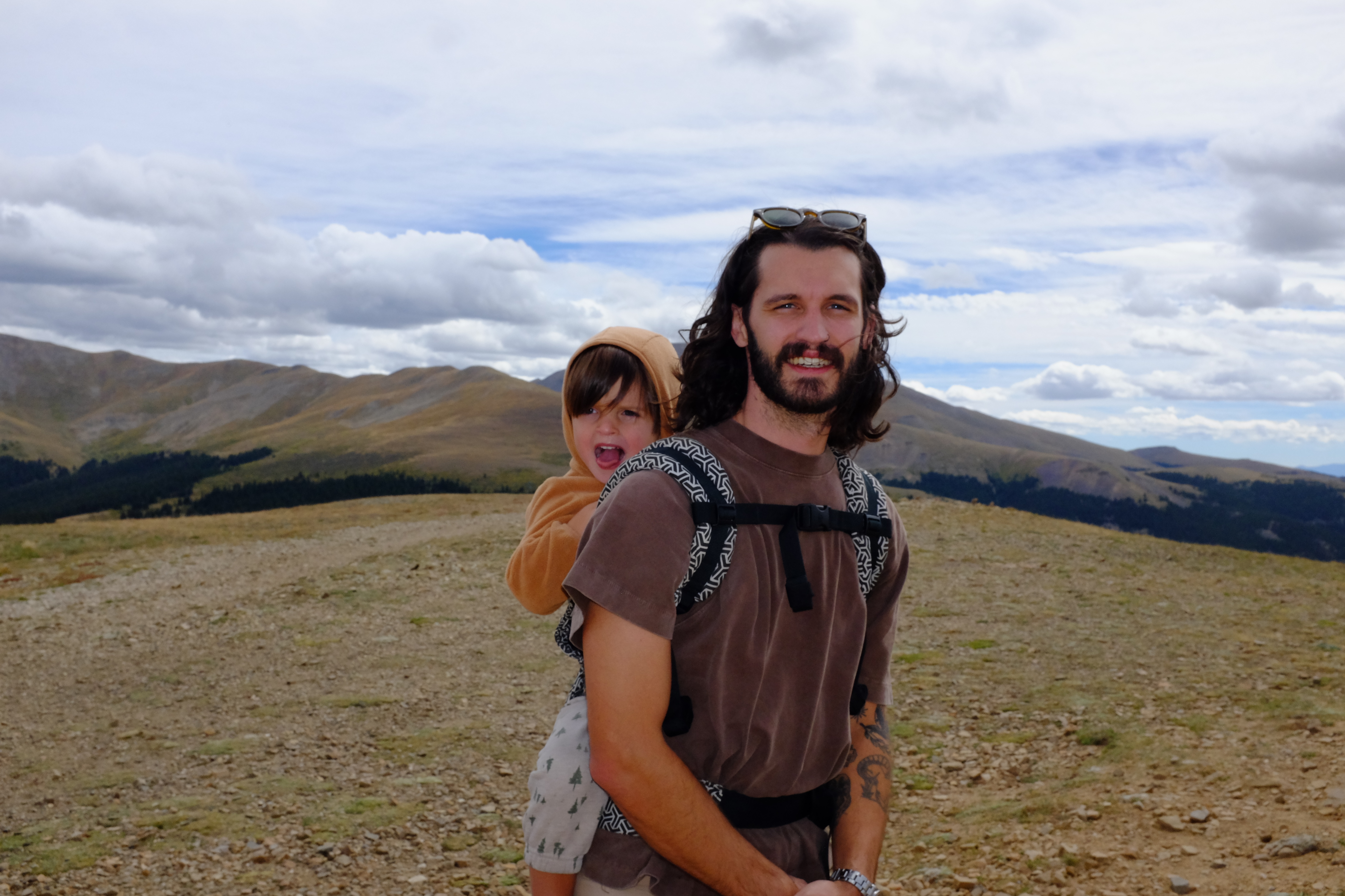 Mark hiking in the mountains with Nico in a backpack carrier.
